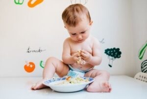 ребенок ест из тарелки руками