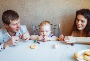 ребенок ест вместе с родителями