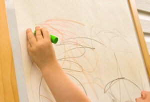ребенок тянется рукой чтобы рисовать