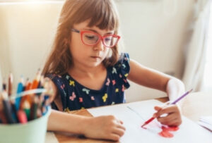девочка в очках рисует