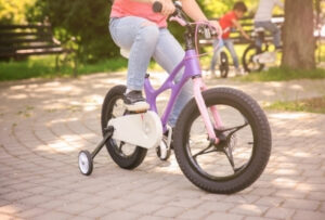 ребенок на 4-колесном велосипеде