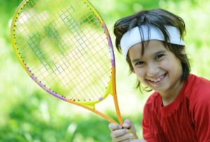 ребенок играет в теннис