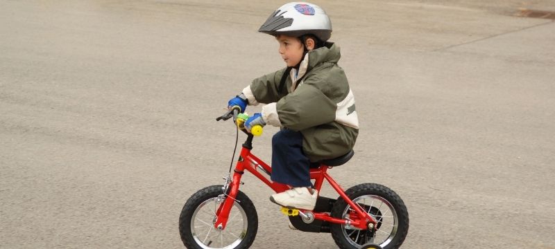 ребенок уверенно едет на велосипеде