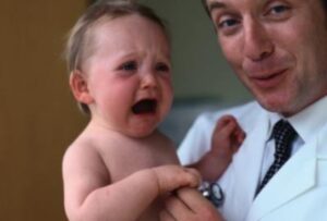 малыш плачет у врача на руках