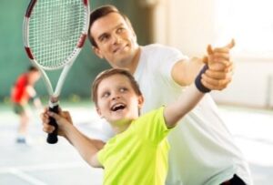 отец учит сына теннису