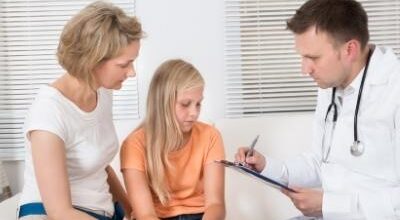 врач записывает на приеме мама и дочь